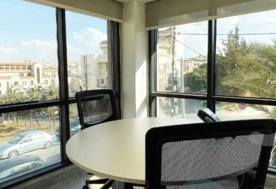 Internal office suite featuring a round meeting table and large windows with city views.