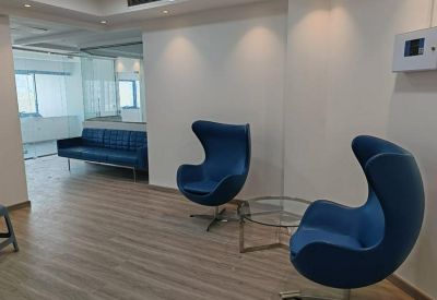 Modern lounge area with blue egg-style chairs and a glass coffee table.