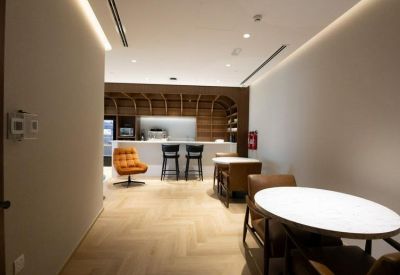 Breakout area with wooden flooring, a white counter, and stylish bar stools.