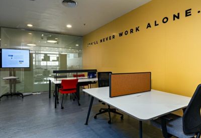 Sleek private office with a yellow feature wall and white minimalist desks.
