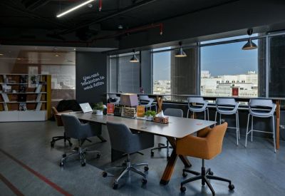 Modern meeting space with a large wooden table and views of the city skyline.
