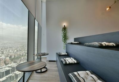Tiered seating lounge with cushions and expansive window views.