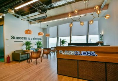 Reception area with a warm wood desk and modern geometric light fixture.