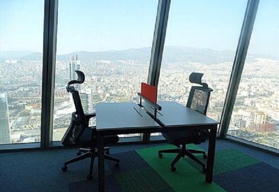 Twin workstation desk with ergonomic chairs overlooking the city.