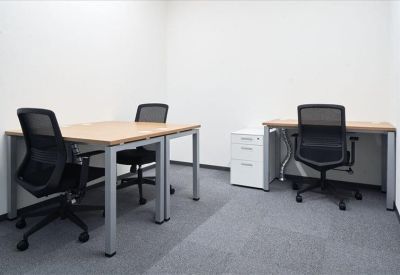 Private internal office suite with two wood-topped desks and black ergonomic chairs.