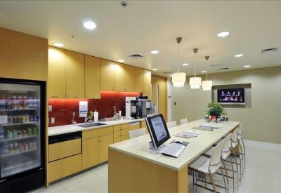 Modern office kitchen and breakout area with a large island and bar seating.