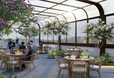 Rooftop dining area with round wooden tables under a curved glass conservatory roof.