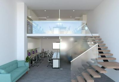 Modern open-plan office with a mezzanine level, glass railings, and a blue sofa.