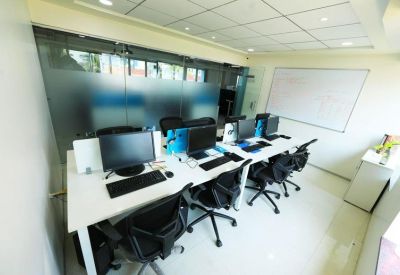 Professional meeting room with a long white desk, glass partitions, and a whiteboard.