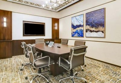 Professional meeting room with a dark wood table, leather chairs, and two blue abstract paintings.
