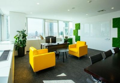 Private office suite with bright yellow armchairs and green moss wall accents.