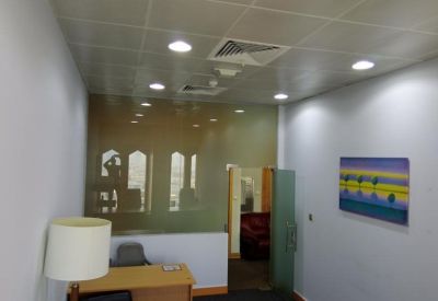Brightly lit reception area with a wooden desk and colorful wall art.