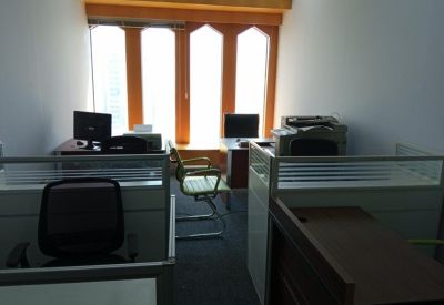 Workspaces with office chairs facing a large window with city views.