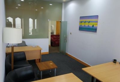 Waiting area featuring black leather armchairs and a small coffee table.