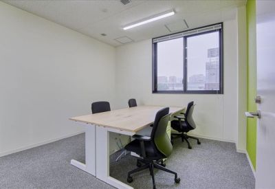 Bright four-person meeting room with a large window and green accents.