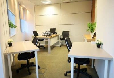 Private office suite with two desks, ergonomic chairs, and indoor plants.