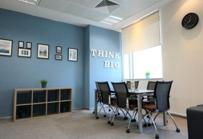 Meeting room featuring a blue feature wall with Think Big text and framed art.