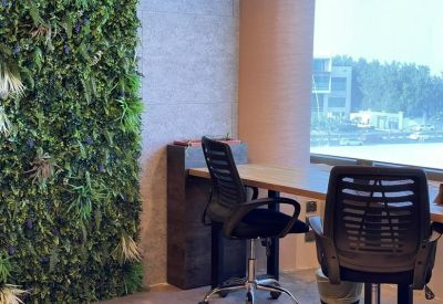 Private workstation with a green living wall and a large window overlooking the city.