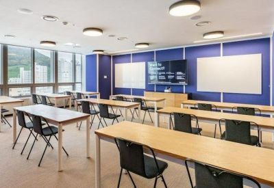 Classroom-style meeting room at BIFC, 133, Jeonpo-daero, featuring blue accent walls and rows of wooden tables.