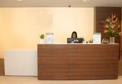 Reception area featuring a wood-paneled desk and a colorful tropical flower arrangement.