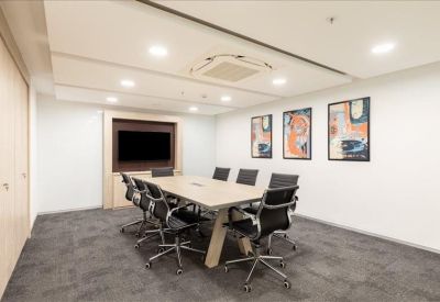Contemporary meeting room with a wooden table, black mesh chairs, and abstract wall art.