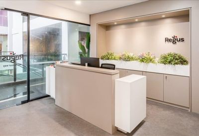 Bright reception desk with branded logo and indoor plants.