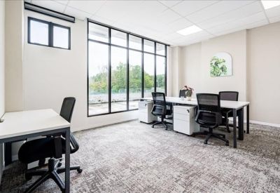 Private office with white desks, black chairs, and natural light.