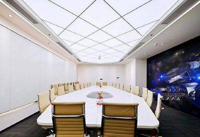 Large conference room with a white oval table and a futuristic backlit grid ceiling.