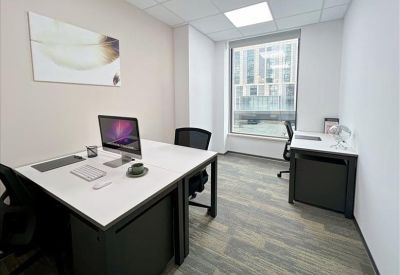 Private office suite with a white desk, computer monitor, and window view.