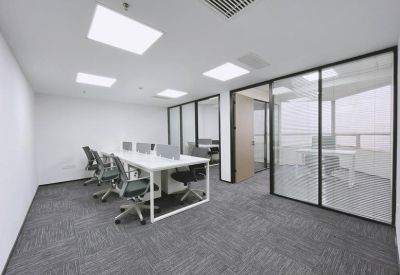 Spacious open-plan workspace at HNA IMC Center with white desks and glass-walled private offices.