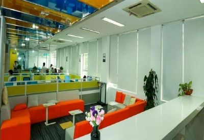 Reception area with bright orange seating and a white counter.