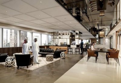 Vibrant lounge area with plush black leather sofas and patterned wall details.