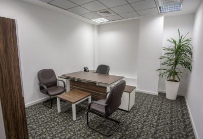Private three-person office suite with a large desk and potted plant.