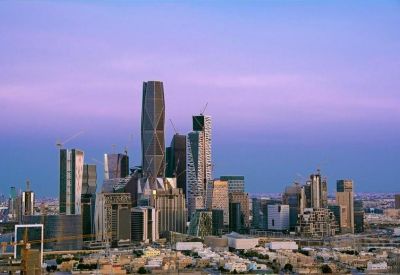 Distant cityscape view of modern skyscrapers under a purple and blue dusk sky.