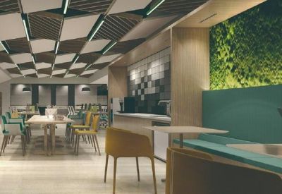 Bright breakout area featuring a large green plant wall and wooden accents.