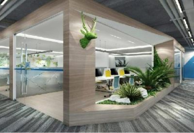 Modern open-plan office with glass-walled pods and an indoor garden feature.