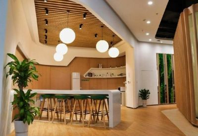 Modern communal breakout area with high stools, white counter, and spherical pendant lighting.