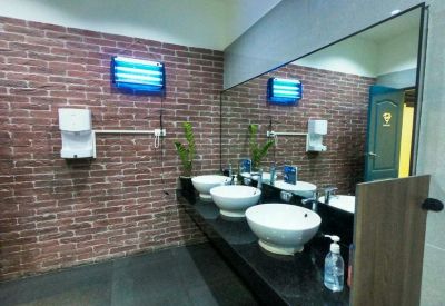 Modern restroom with brick-patterned walls and stylish white vessel sinks.