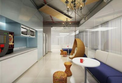 Communal break area with a blue velvet sofa, egg-shaped hanging chair, and wooden stools under a chandelier.
