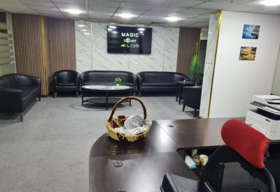 Modern reception area with black leather sofas and a branded feature wall.