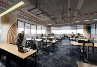 Sunlit open-plan office with rows of wooden desks, ergonomic chairs, and industrial ceiling details.