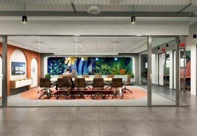 Glass-walled boardroom with a long conference table and a colorful nature-themed feature wall.