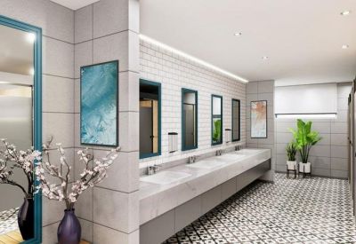 Modern restroom facility featuring patterned floor tiles, large mirrors, and decorative floral vases.