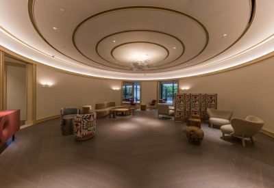 Circular lounge area with curved ceiling design and various armchairs.