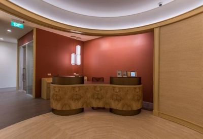 Modern reception area with a curved patterned desk and warm lighting.