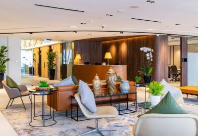 Stylish lobby with tan leather armchairs, decorative vases, and warm wood-paneled walls.