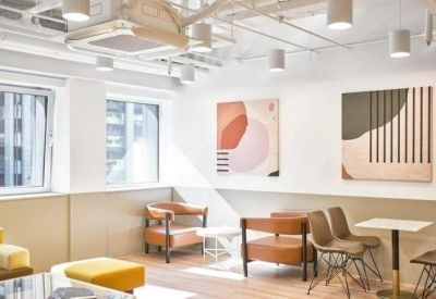 Chic breakout area with mid-century modern leather armchairs and colorful abstract art.