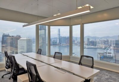 Long boardroom table with black mesh chairs and panoramic harbor views.