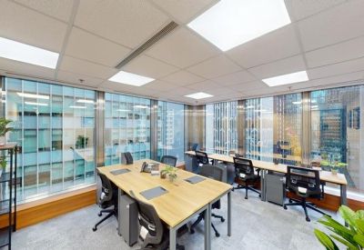 Bright corner office with six desks and wrap-around windows.