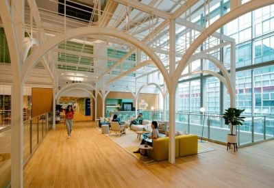 Open-plan coworking area with architectural white timber arches and various comfortable seating options.